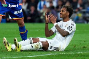 Cầu thủ Rodrygo của Real Madrid ngồi trên sân sau một pha va chạm